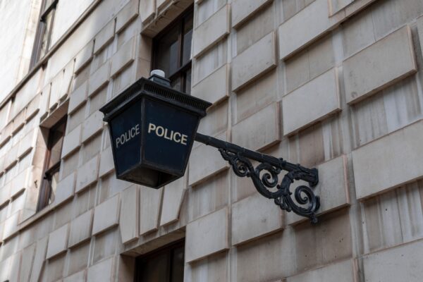A blue Police lamp on a grey concrete building