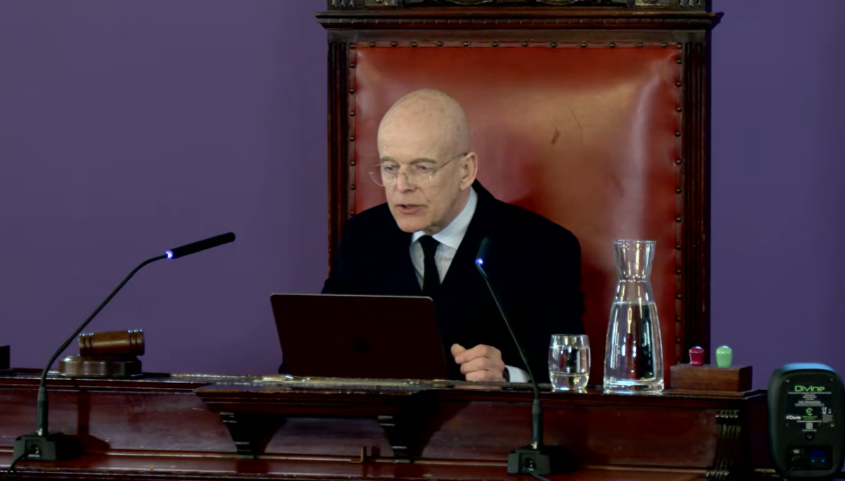 Inquiry Chair Sir Adrian Fulford (pictured) delivers his remarks at Liverpool Town Hall upon publishing his Phase 1 report. Credit: Southport Inquiry / YouTube.